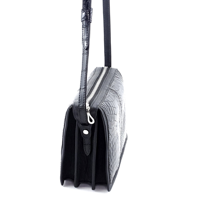 Riley handbag in black glaze crocodile elbows showing a close up of the side gussetts, there are 3