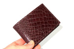 hand with Burgundy printed leather small men's wallet held in hand