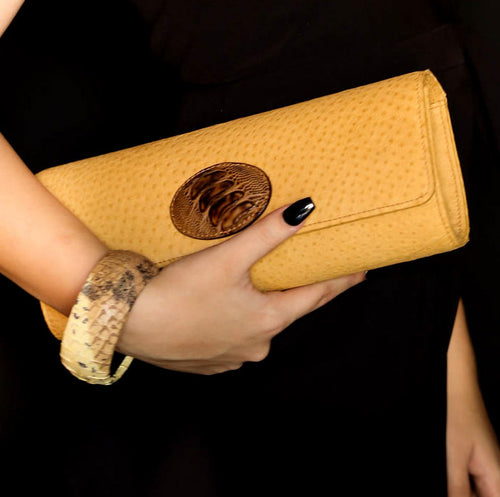 Bangle medium (Kim) moulded round decorated leather jewellery - shown on model holding a wild harry meredith clutch emu skin bag